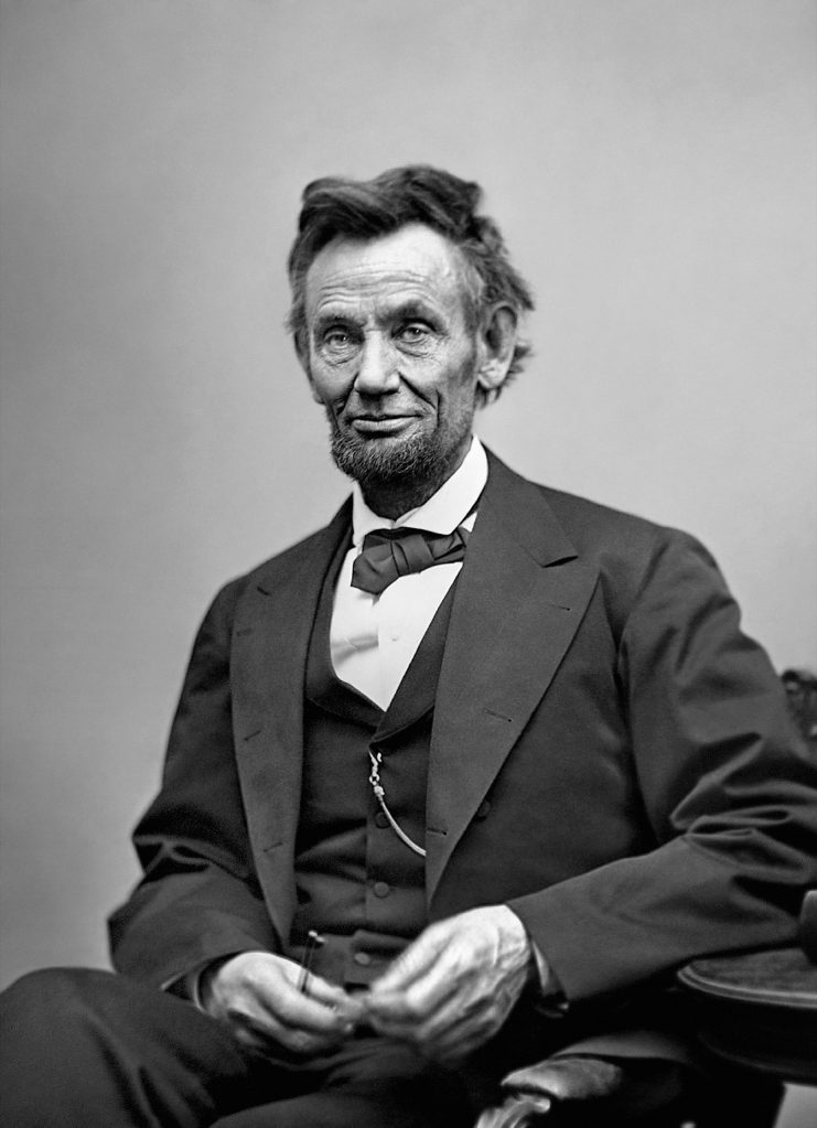 Black and white portrait of Abraham Lincoln, seated and looking at camera.