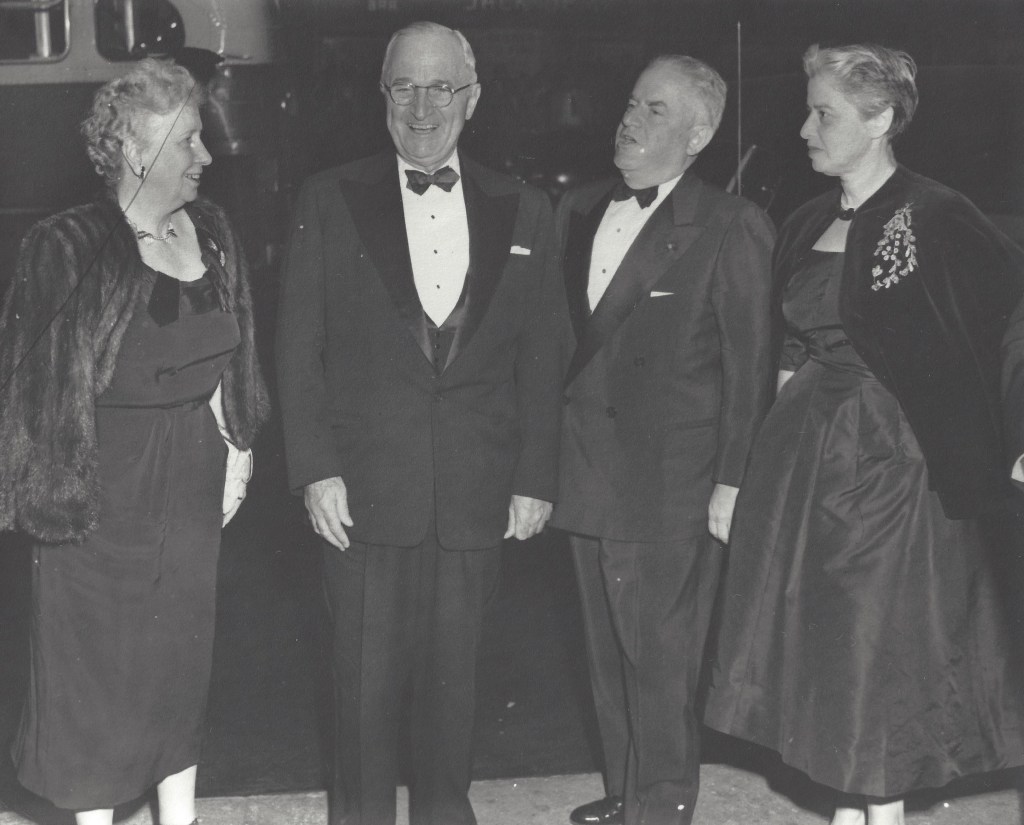 President Harry Truman laughs while standing with his wife and two guests at The National Theatre.
